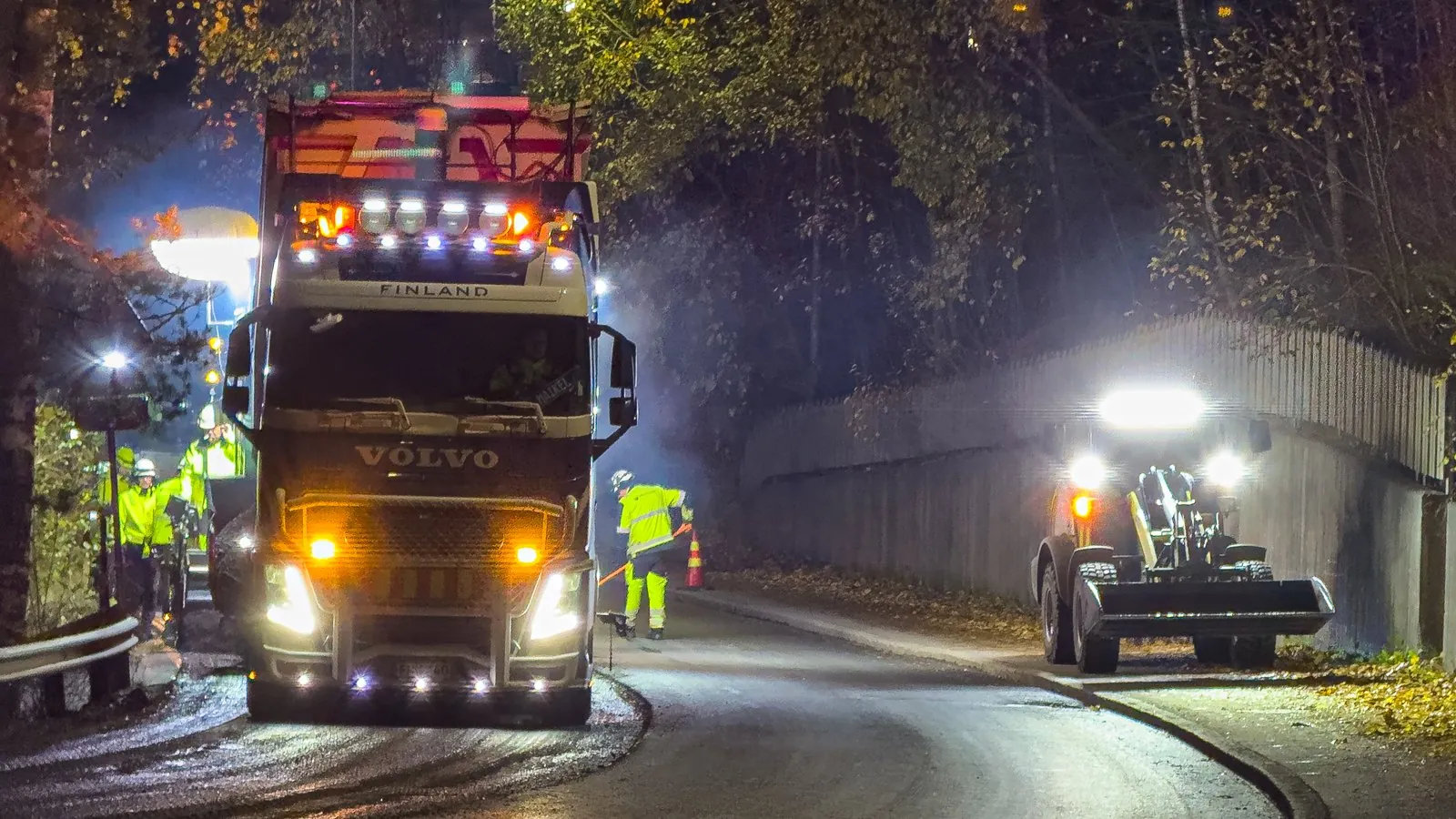 Asfalttikallio paving crew working on a residential street at night